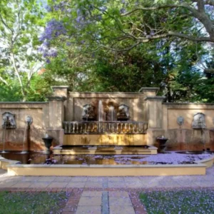 The fountain terrace and loungers in the oak-shaded garden at Franschhoek Country House and Villas