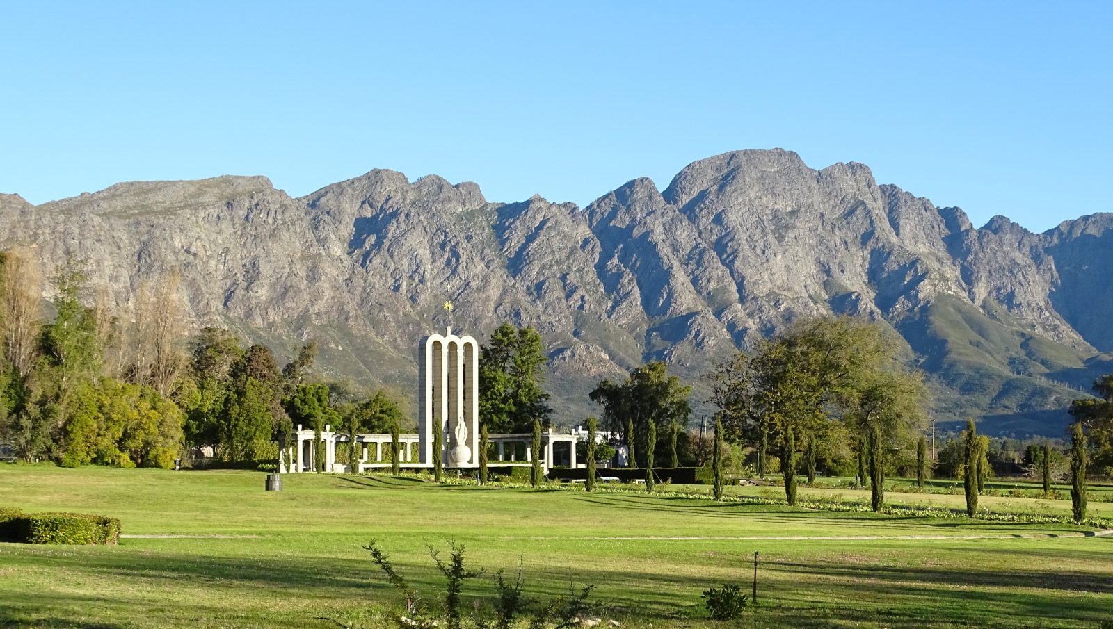 The three arches of the Huguenot Monument in Franschhoek below the valley mountains
