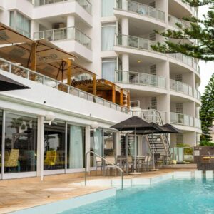 A hotel with a swimming pool in front of a building at Peninsula All Suite Hotel by Dream Resorts in Cape Town