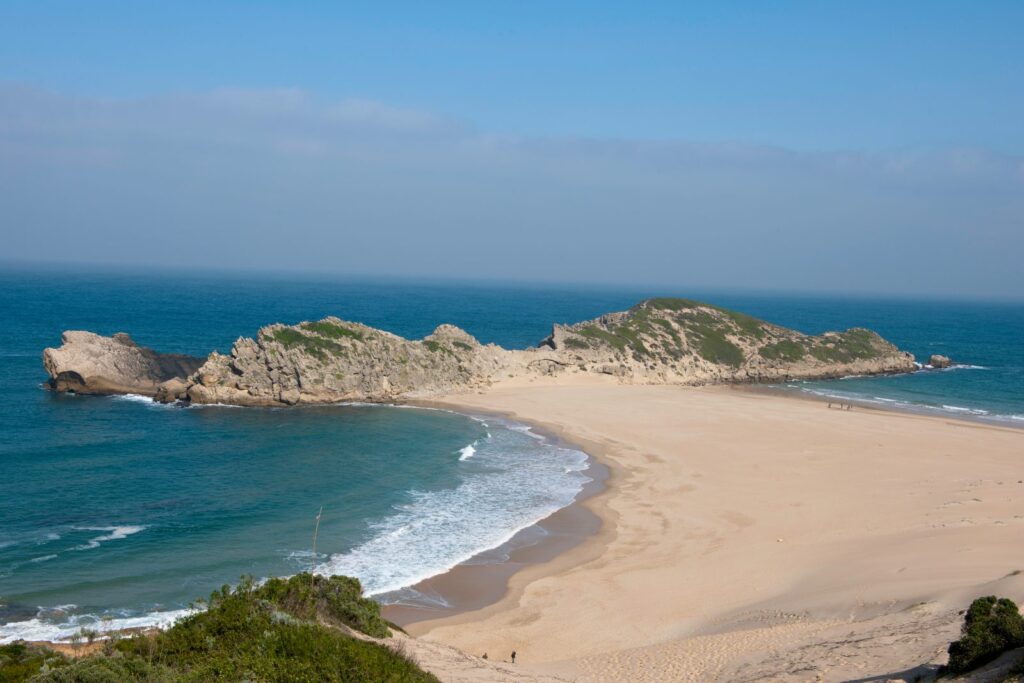 The Robberg peninsula reaching into the sea beyond the curve of the beach at Plettenberg Bay