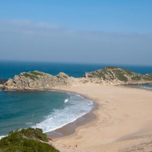 The Robberg peninsula reaching into the sea beyond the curve of the beach at Plettenberg Bay
