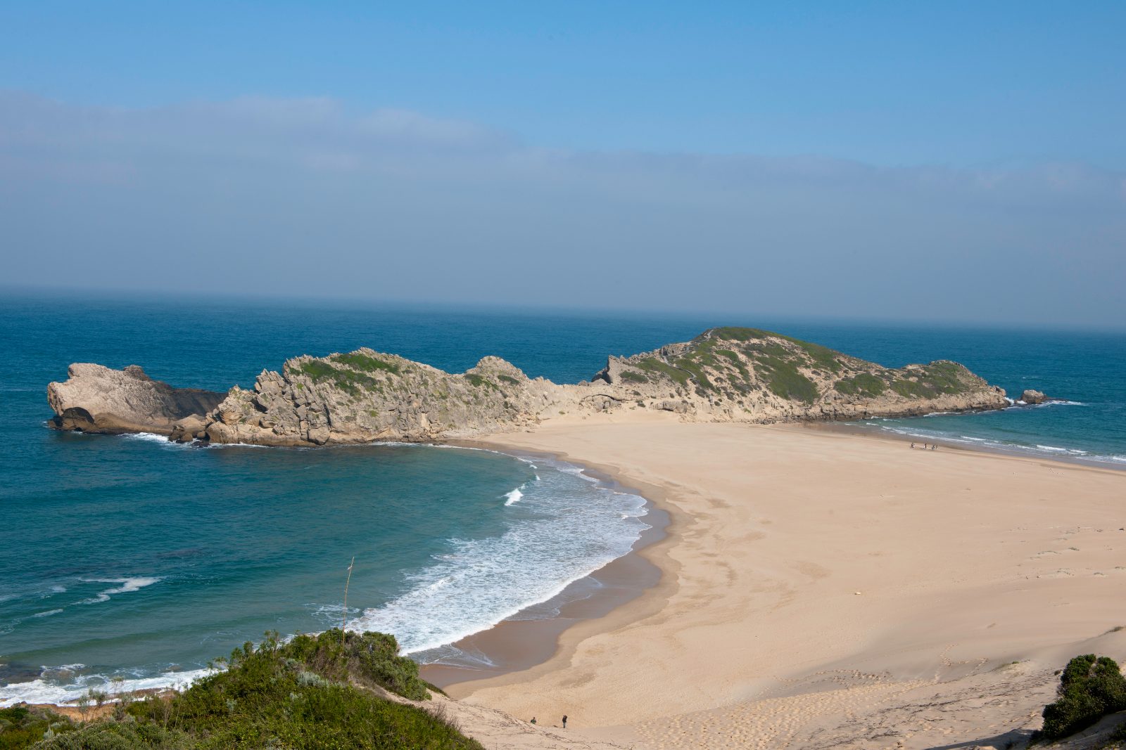 The Robberg peninsula reaching into the sea beyond the curve of the beach at Plettenberg Bay