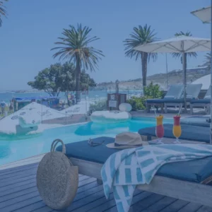 Loungers and palms around the pool deck at The Bay Hotel in Camps Bay, Cape Town