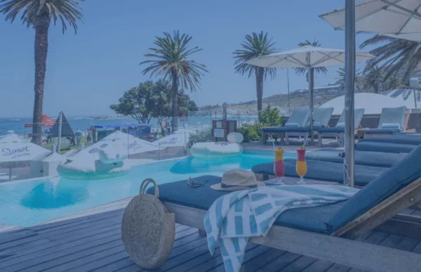 Loungers and palms around the pool deck at The Bay Hotel in Camps Bay, Cape Town