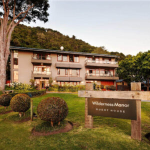 Exterior and garden of Wilderness Manor Guest House with the hillside behind