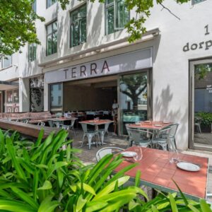 A restaurant with tables and chairs in front of a building at 107 Dorpstraat Boutique Hotel in Stellenbosch