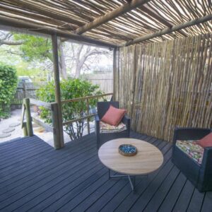 A deck with two chairs and a table on a deck at 139 Longships Plett in Plettenberg Bay