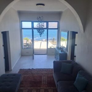 A living room with a couch and a view of the ocean at 210 on Main in Kalk Bay