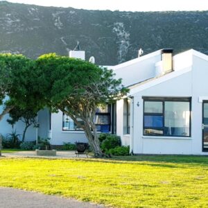A white house with trees in front of it at 4 On Hoffman Seaview in Agulhas