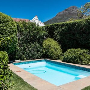 A swimming pool in a garden with bushes at 5 Camp Street Guesthouse & Self-catering in Cape Town