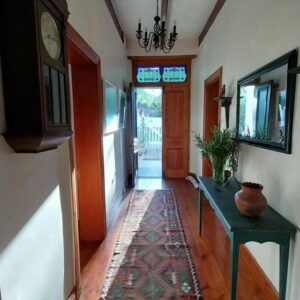 A hallway of a home with a table and a clock at 6 Olives in Darling