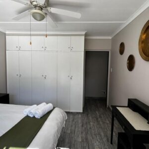 A bedroom with a bed and a ceiling fan at 9 Serendipity Stay in George