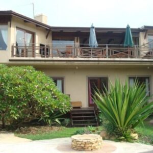 A house with two umbrellas on top of it at A Whale of a View Bed & Breakfast in Plettenberg Bay