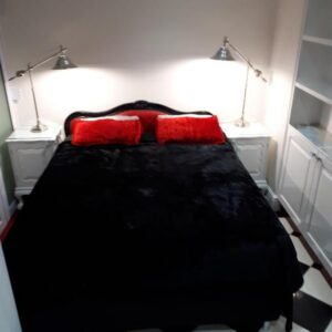 A bedroom with a black bed with two red pillows at AI Adrian D'Cap Boutique Manor in Stellenbosch