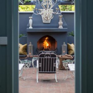 A table and chairs in front of a fireplace at Akademie Street Boutique Hotel in Franschhoek