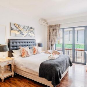 A bedroom with a bed and a balcony at Albatross Guest House Bantry Bay in Cape Town