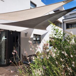 A courtyard with shade sails and a flowering garden at Albatross Guesthouse in Langebaan