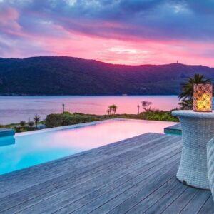 A villa with a pool and a view of the water at Amanzi Island Boutique Hotel in Knysna