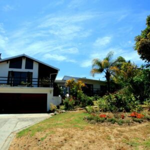 A house with a garage in front of a yard at Annika Self-catering and B&B in Stellenbosch