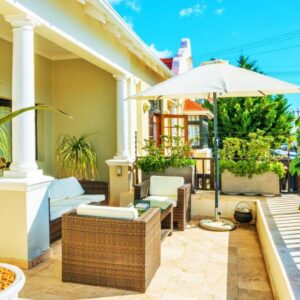 A patio with plants and an umbrella on a house at Antrim Luxury Villa in Cape Town