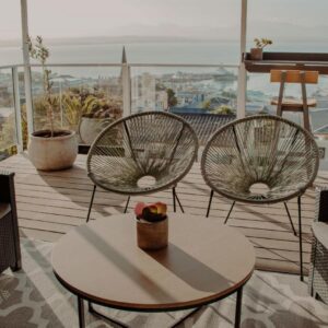 Two chairs and a table on a balcony with a view at Aqua Marina Guest House in Mossel Bay