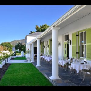 A patio with tables and chairs on a house at Ashbourne Boutique Guest House in Franschhoek