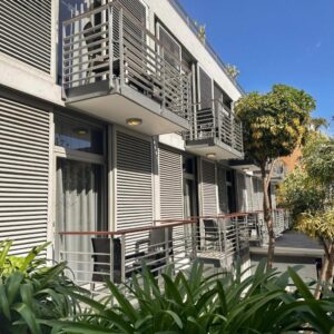 An apartment building with balconies and tables and chairs at Atlantic Affair Boutique Hotel in Cape Town