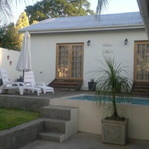 A villa with a swimming pool and a house at B&B on Church in Oudtshoorn