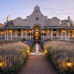 A large white house with a statue in front of it at Bakenskraal Ostrich Palace in Oudtshoorn
