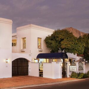 A white house with a gate and a tree at Batavia Boutique Hotel in Stellenbosch