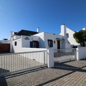 A white house with a gate in front of it at Baywatch Paternoster - The Cottage in Paternoster