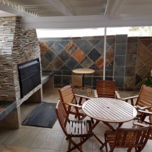 An outdoor patio with a braai and table at Beautiful Abalone in Hermanus