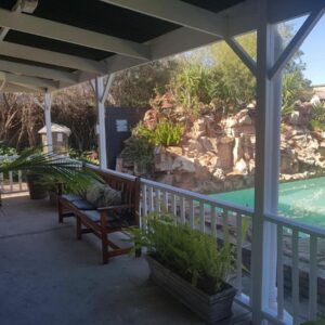 A porch with a bench and a swimming pool at Beit Shalom before known as Best Little Guesthouse in Oudtshoorn