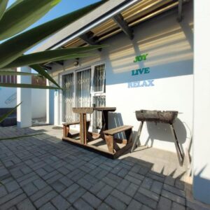A patio of a house with a table and a grill at Bella Mia Langebaan in Langebaan