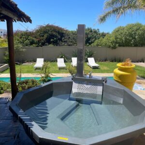 A swimming pool with a table in a backyard at Bird's View Guest Accommodation in Hermanus