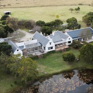 An aerial view of a house with a pond at Bitou River Lodge in Plettenberg Bay