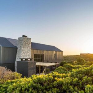A house in the middle of a field with bushes at Black Barn At Romansbaai in Gansbaai