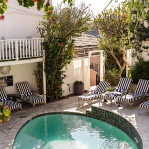 A patio with chairs and a swimming pool at Blackheath Lodge by The Oyster Collection in Cape Town