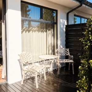 A patio with two chairs and a table on a deck at Blix Inn Guesthouse in Stellenbosch