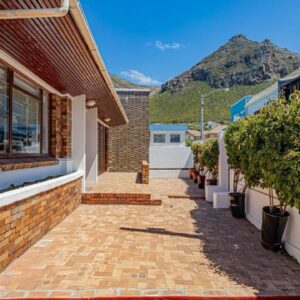 A walkway between two buildings with a mountain in the background at Blossom Boutique Guesthouse in Muizenberg