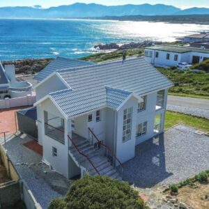 An aerial view of a house with the ocean at Bluemist Accommodation in Gansbaai