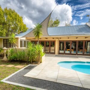 A house with a swimming pool in the yard at Botanica Guest House in George