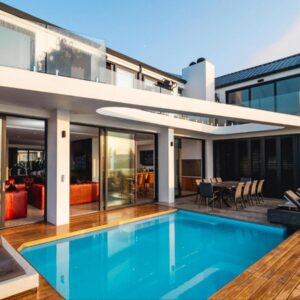 A house with a swimming pool in front of it at Boutique Ocean Views Guesthouse in Hermanus