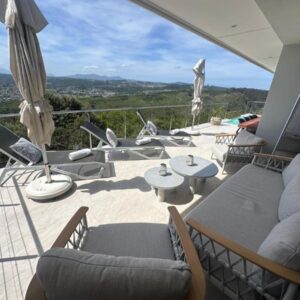 A balcony with lounge seating, umbrellas and a valley view at BQ6 Pezula in Knysna