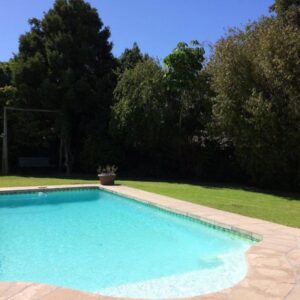 A large blue swimming pool in a yard at Camelot in Constantia in Cape Town