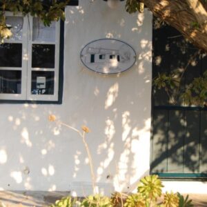 A white house with a window and a door at Cape Creek Cottage, Luxury Coastal Getaway in Struisbaai