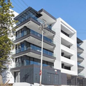 A tall white building with blue windows at Casa on Quendon by Totalstay in Cape Town