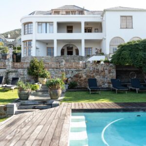 A home with a swimming pool and a house at Chartfield Guesthouse in Kalk Bay