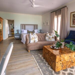 A guest suite lounge with seating and a coffee table at Chateau de Marine Boutique Hotel in Struisbaai