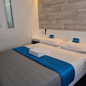 A bedroom with a bed with a blue blanket at Check Inn Hotel in Cape Town